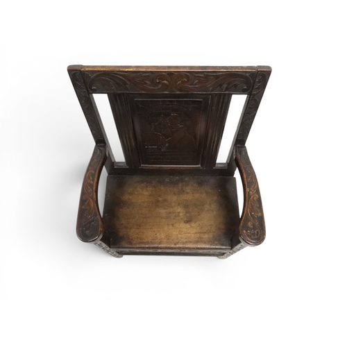 2029 - A 19TH CENTURY OAK WAINSCOT STYLE OAK ARMCHAIR&nbsp;with carved panel back depicting a monk tasting ... 