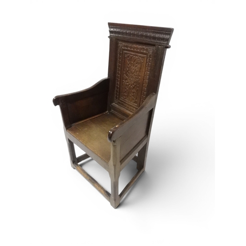 2030 - A 18TH CENTURY OAK WAINSCOT STYLE OAK ARMCHAIR&nbsp;with panel back carved with foliate motifs over ... 