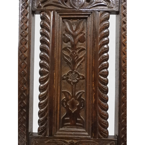 2031 - A PAIR OF 17TH CENTURY STYLE OAK HALL CHAIRS with floral carved panel backs surmounted with twinned ... 