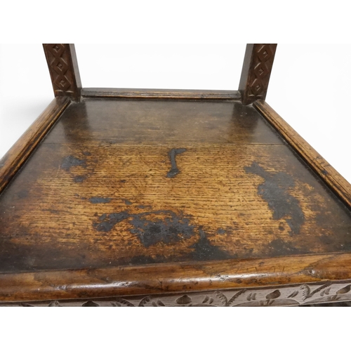 2031 - A PAIR OF 17TH CENTURY STYLE OAK HALL CHAIRS with floral carved panel backs surmounted with twinned ... 