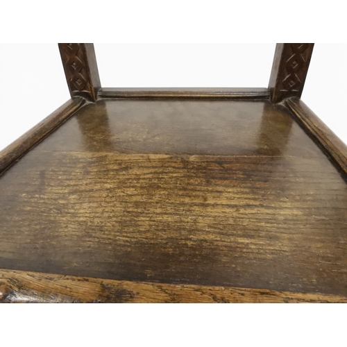 2031 - A PAIR OF 17TH CENTURY STYLE OAK HALL CHAIRS with floral carved panel backs surmounted with twinned ... 