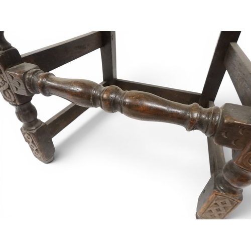 2031 - A PAIR OF 17TH CENTURY STYLE OAK HALL CHAIRS with floral carved panel backs surmounted with twinned ... 
