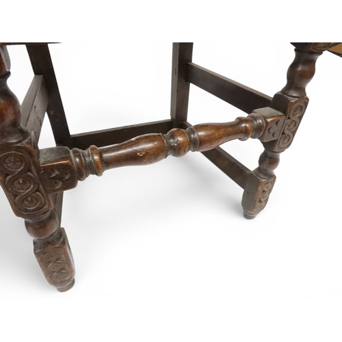 2031 - A PAIR OF 17TH CENTURY STYLE OAK HALL CHAIRS with floral carved panel backs surmounted with twinned ... 