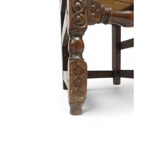2031 - A PAIR OF 17TH CENTURY STYLE OAK HALL CHAIRS with floral carved panel backs surmounted with twinned ... 