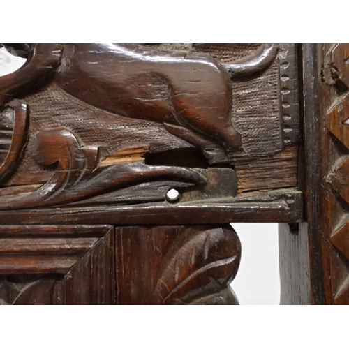 2031 - A PAIR OF 17TH CENTURY STYLE OAK HALL CHAIRS with floral carved panel backs surmounted with twinned ... 