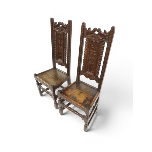 2031 - A PAIR OF 17TH CENTURY STYLE OAK HALL CHAIRS with floral carved panel backs surmounted with twinned ... 