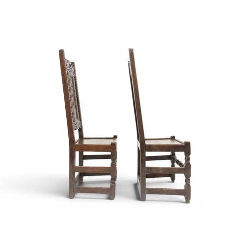 2031 - A PAIR OF 17TH CENTURY STYLE OAK HALL CHAIRS with floral carved panel backs surmounted with twinned ... 
