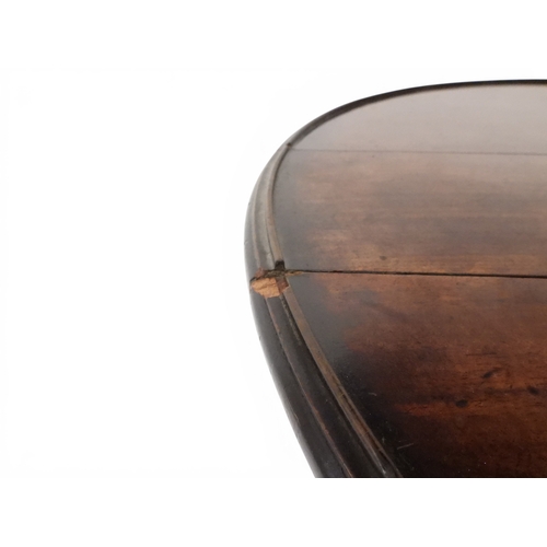 2037 - A GEORGIAN MAHOGANY TWO TIER DUMB WAITERwith two circular drop side tiers of graduating size on turn... 