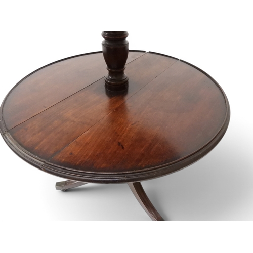 2037 - A GEORGIAN MAHOGANY TWO TIER DUMB WAITERwith two circular drop side tiers of graduating size on turn... 