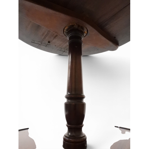 2037 - A GEORGIAN MAHOGANY TWO TIER DUMB WAITERwith two circular drop side tiers of graduating size on turn... 