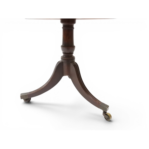 2037 - A GEORGIAN MAHOGANY TWO TIER DUMB WAITERwith two circular drop side tiers of graduating size on turn... 
