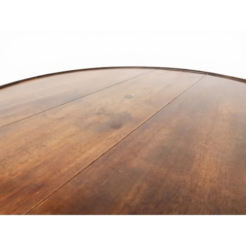 2037 - A GEORGIAN MAHOGANY TWO TIER DUMB WAITERwith two circular drop side tiers of graduating size on turn... 
