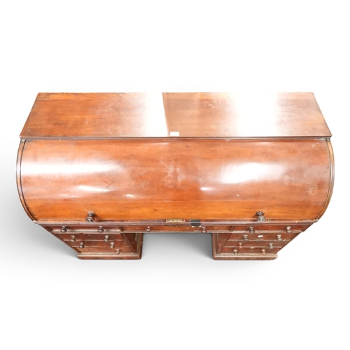 1 - A 19th century mahogany cylinder topped pedestal writing desk, cylinder top concealing pitted writin...