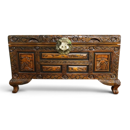 16 - An early 20th century Chinese hardwood chest carved on all sides with mountainous scenes within foli...