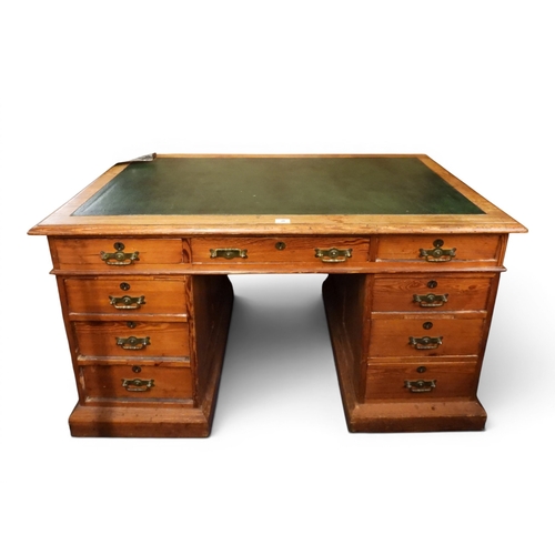 20 - A late 19th pitch pine pedestal desk with green skiver top over long central frieze drawer flanked b...