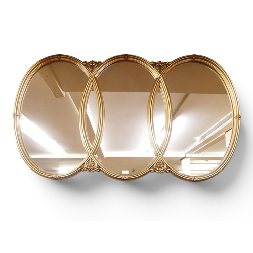 24 - A large contemporary gilt framed wall mirror with overlapping oval frames with foliate motifs, 90cm ...