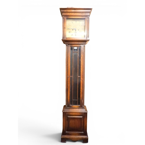 27 - An early 20th century oak cased Ingersoll longcase clock with brass dial bearing Arabic and Roman nu...