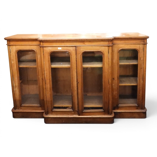 28 - A Victorian mahogany veneered breakfront bookcase with pair of central glazed doors flanked by furth...