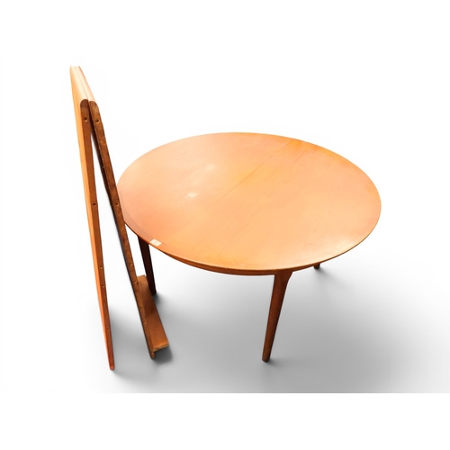 36 - A mid 20th century teak Scandinavian style circular extending dining table with two additional leave...