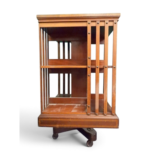 4 - An early 20th century mahogany and fruitwood veneered two tier revolving bookcase, 85cm high x 49cm ...