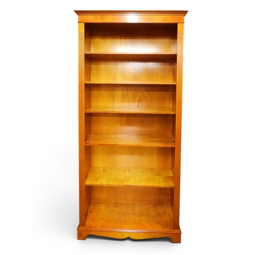 49 - A 20th century maple veneered open bookcase with dentil cornice over five open shelves on plinth bas...