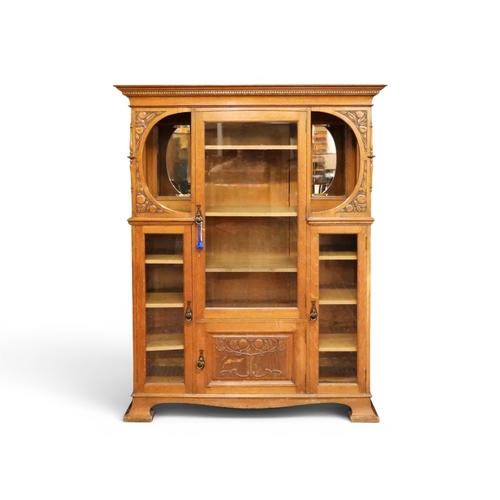 5 - A late 19th century oak Arts & Crafts bookcase with moulded dentil cornice over central glazed d...