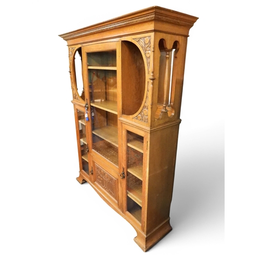 5 - A late 19th century oak Arts & Crafts bookcase with moulded dentil cornice over central glazed d...