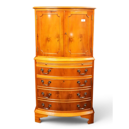 50 - A 20th century yew wood veneered bow front drinks cabinet with pair of beaded doors over pull out sl...
