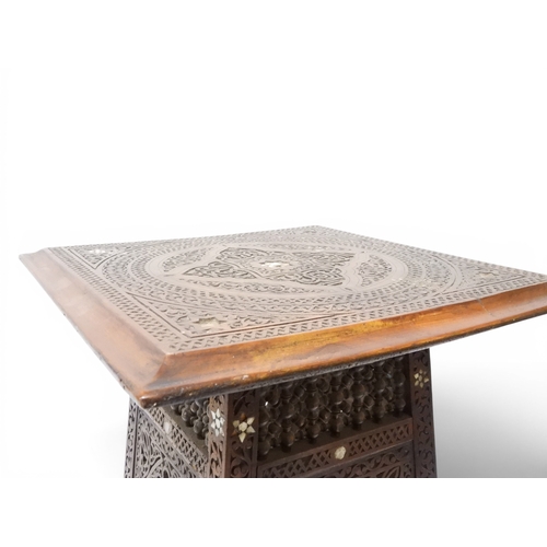 2008 - A LATE 19TH CENTURY MOORISH STYLE TWO TIER OCCASIONAL TABLE square top extensively carved with Arabi... 