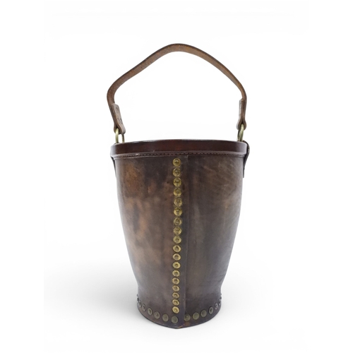 2018 - A 20TH CENTURY REPRODUCTION OF AN EARLY 19TH CENTURY LEATHER FIRE BUCKETwith brass rivetted body emb... 