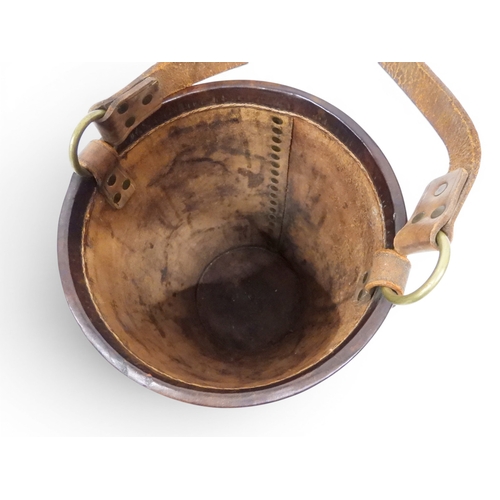 2018 - A 20TH CENTURY REPRODUCTION OF AN EARLY 19TH CENTURY LEATHER FIRE BUCKETwith brass rivetted body emb... 