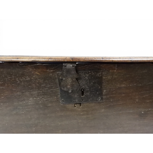 2020 - AN 18TH CENTURY OAK SWORD CHESTwith two plank hinged lid with wrought iron fittings on fret cut supp... 