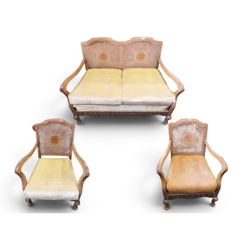 12 - An early 20th century walnut framed bergere three piece suite consisting two seat settee, 83cm high ... 