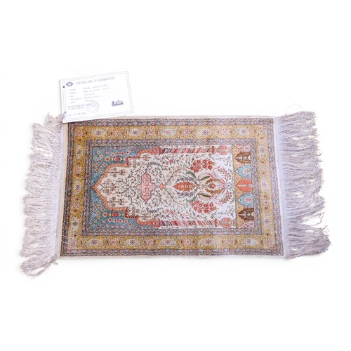 21 - An ivory ground Northwest Anatolian pure silk double knotted Hereke prayer rug with extensive floral... 