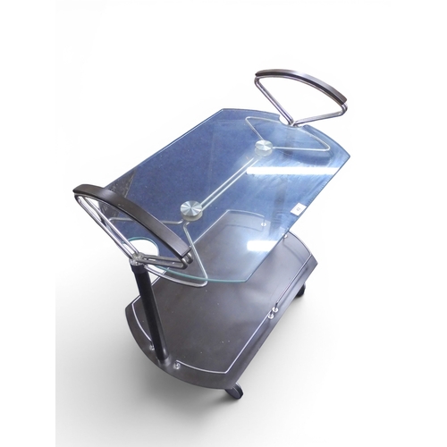 43 - A late 20th century Italian IMS modernist drinks/cocktail trolley with shaped glass top on dark stai... 