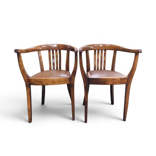 6 - A pair of early 20th century oak framed horseshoe back elbow armchairs with brown Rexine seats on ta... 