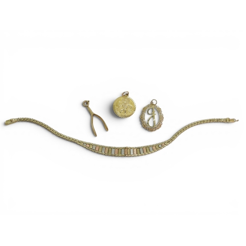 712 - A collection of 9ct gold items, a wishbone pendant, a tricolour bracelet, a 'J' pendant and a St. Ch... 