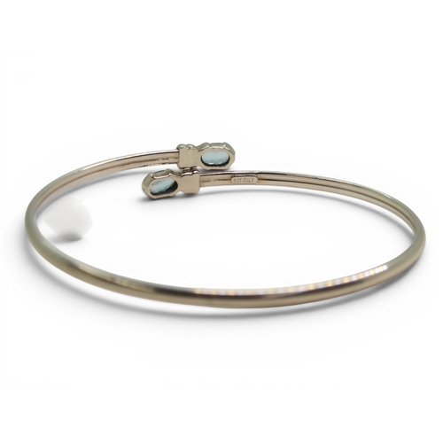 734 - A 9ct white gold bangle set with blue topaz, weight 4.1gms