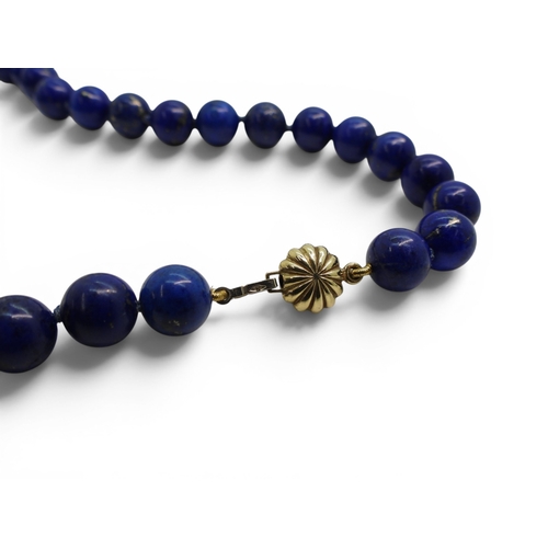 739 - A string of lapis lazuli beads with a 9ct gold clasp, together with a pair of matching earrings.