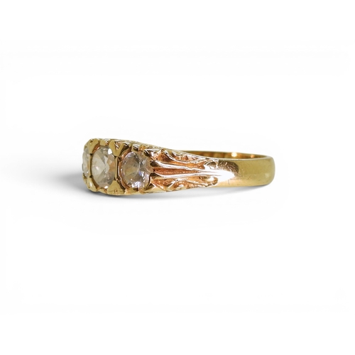 756 - A three clear gem set ring on a decorative scroll mount, size O, weight 3.4gms.