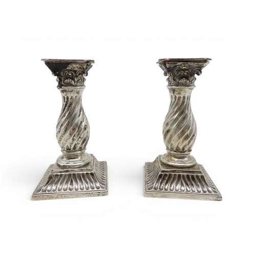 907 - A pair of silver candlesticks, probably Martin Hall & Co, modelled as fluted Corinthian columns,... 