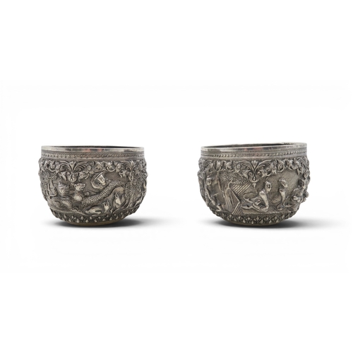 2403 - A PAIR OF BURMESE SILVER BOWLSwith all-over repousse decoration of deities, figures and animals, wit... 