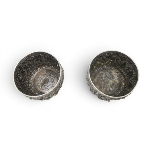 2403 - A PAIR OF BURMESE SILVER BOWLSwith all-over repousse decoration of deities, figures and animals, wit... 