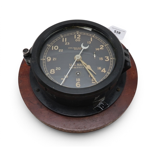 A U.S. Navy bulkhead clock by the Chelsea Clock Co. of Boston, serial no. 27537 E, set upon an inlaid wooden plaque