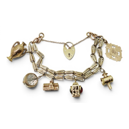A yellow metal bracelet with applied '10' stamp, with 9ct gold heart shaped clasp and five 9ct gold charms and one in yellow metal. Weight all together 47.7gms