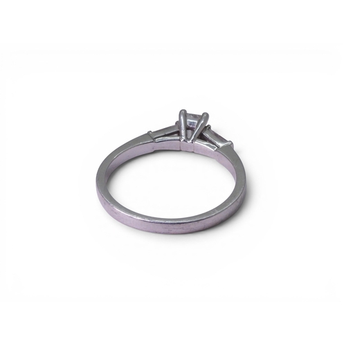 707 - A platinum and diamond three stone ring set with a GIA inscribed emerald cut diamond of estimated ap... 