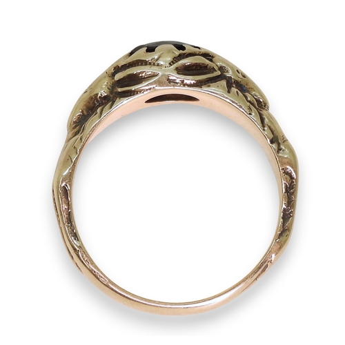 743 - A yellow metal ring set with a garnet with a stag to each shoulder, the antlers make up the claws of... 