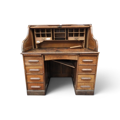 1 - A large early 20th century oak roll top desk with tambour fronted writing compartment on twinned fou... 