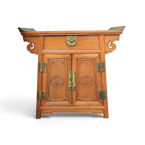 19 - A small 20th century Chinese style teak altar cabinet with single drawer over pair of panel doors, 7... 