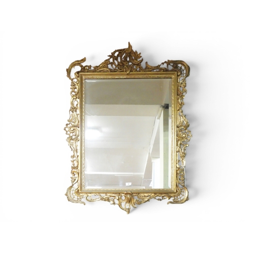 20 - A 19th century gilt gesso framed wall mirror with scrolled foliate frame and later bevelled glass mi... 